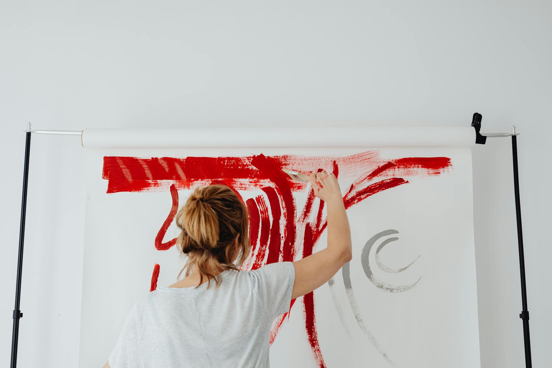 back view of a woman painting on white textile